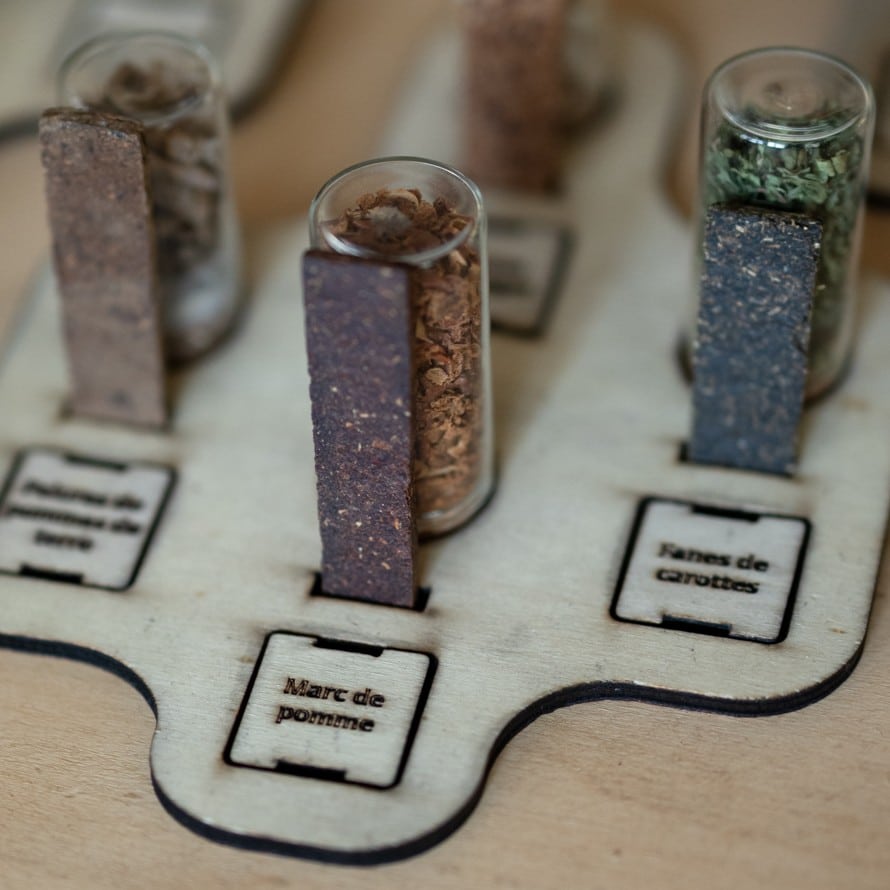 Trois échantillons de matières obtenues par thermocompression du marc de pomme, des fanes de carottes et des épluchures de pommes de terre